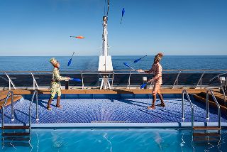 Top deck of an MSC cruise ship featuring a swimming pool, sun loungers, and panoramic ocean views.